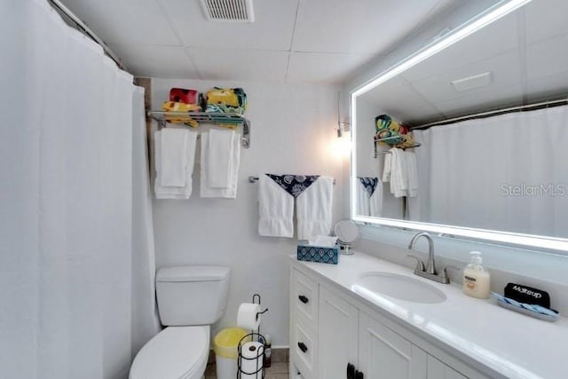 full bath featuring vanity, visible vents, toilet, and a paneled ceiling