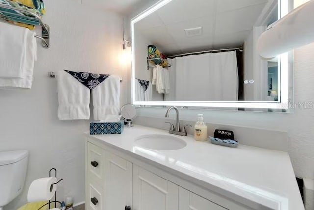 bathroom with visible vents, toilet, a shower with shower curtain, and vanity