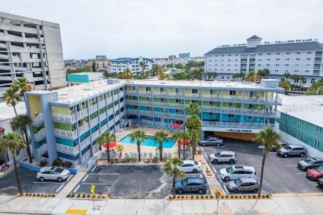 view of building exterior featuring uncovered parking and a city view