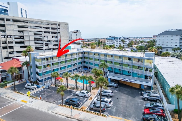 view of property with uncovered parking and a city view