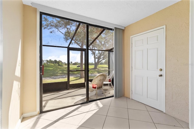 2073 Skimmer Ct W Unit 211, Clearwater, FL 33762 - doorway to outside with a textured wall, light tile patterned flooring, a healthy amount of sunlight, and a wall of windows