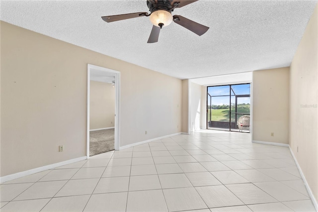2073 Skimmer Ct W Unit 211, Clearwater, FL 33762 - spare room featuring baseboards, floor to ceiling windows, a ceiling fan, and a textured ceiling