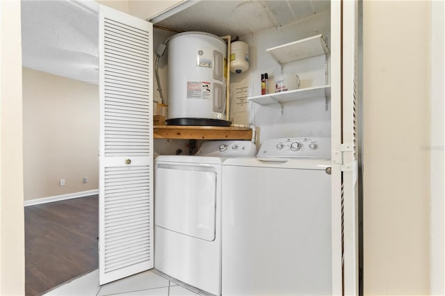 2073 Skimmer Ct W Unit 211, Clearwater, FL 33762 - clothes washing area featuring independent washer and dryer, laundry area, baseboards, wood finished floors, and electric water heater