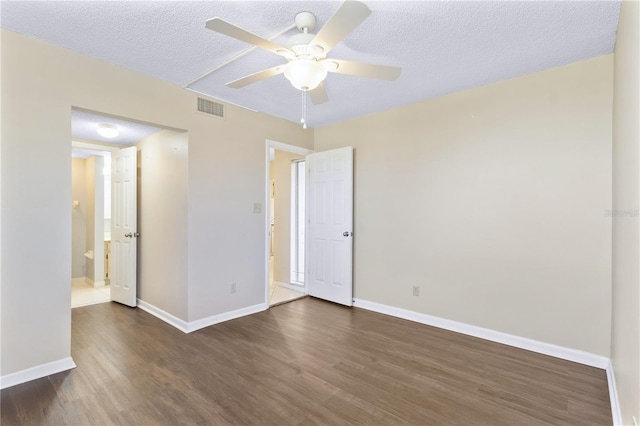 2073 Skimmer Ct W Unit 211, Clearwater, FL 33762 - unfurnished bedroom featuring baseboards, dark wood finished floors, a textured ceiling, and visible vents