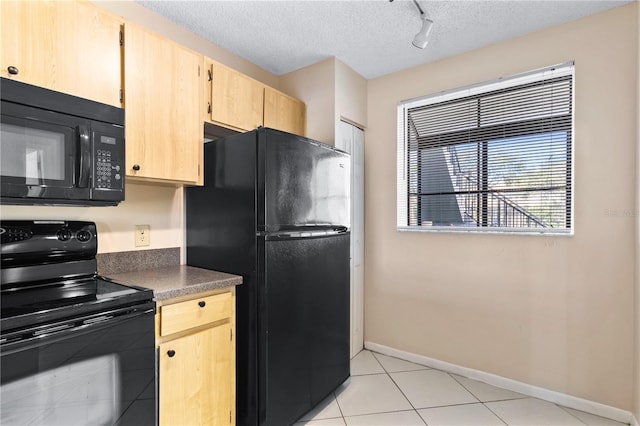 2073 Skimmer Ct W Unit 211, Clearwater, FL 33762 - kitchen featuring a textured ceiling, light tile patterned floors, baseboards, black appliances, and light brown cabinets