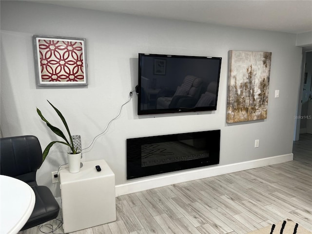 living room with baseboards and light wood finished floors