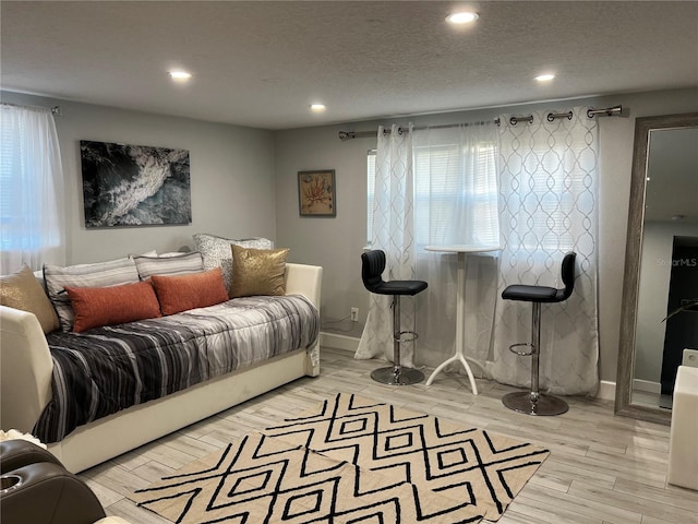 bedroom featuring light wood-style flooring, multiple windows, a textured ceiling, and recessed lighting