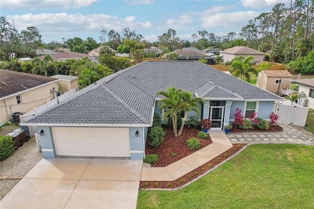 ranch-style house with stucco siding, a front yard, fence, a garage, and driveway