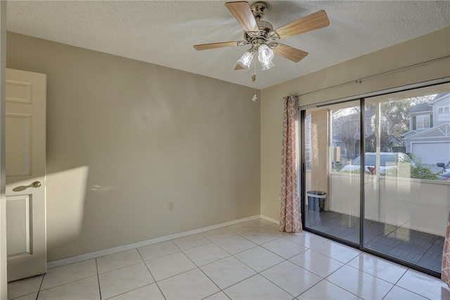 spare room featuring light tile patterned flooring, ceiling fan, a textured ceiling, and baseboards