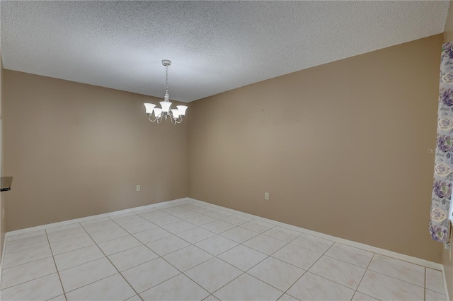 empty room with an inviting chandelier and a textured ceiling