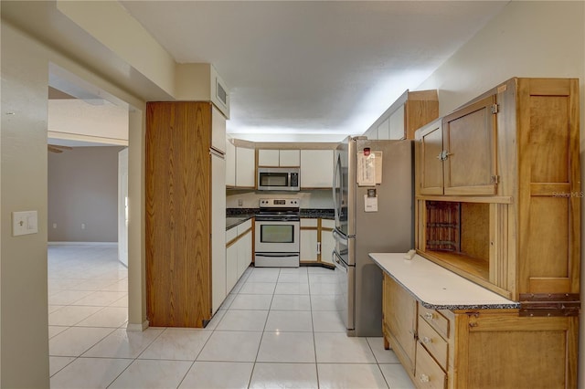 kitchen featuring dark countertops, visible vents, stainless steel appliances, and light tile patterned flooring