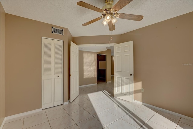 interior space featuring light tile patterned floors, a textured ceiling, and visible vents