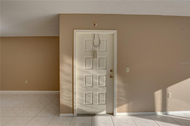 foyer with light tile patterned floors and baseboards