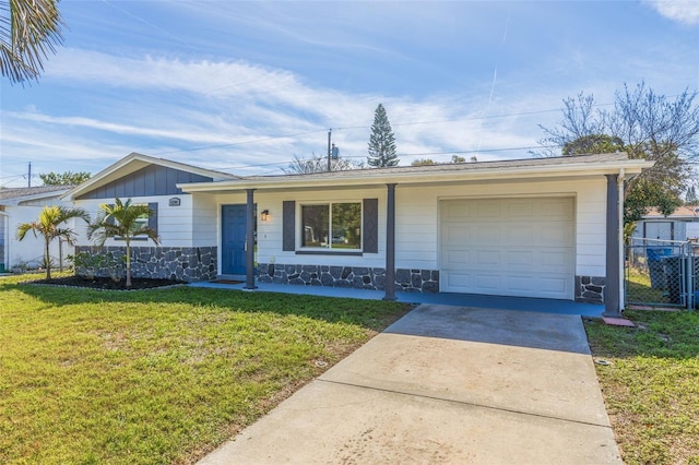 ranch-style home with driveway, a garage, stone siding, board and batten siding, and a front yard