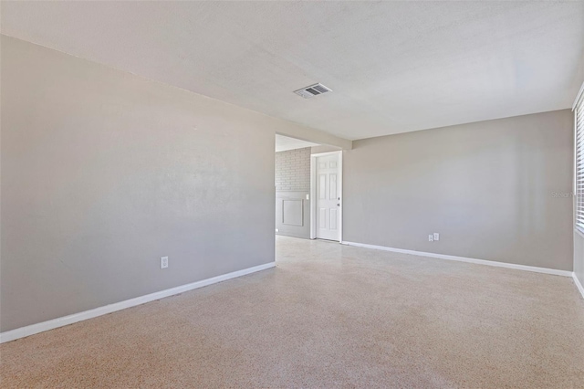 unfurnished room featuring visible vents, a textured ceiling, baseboards, and speckled floor