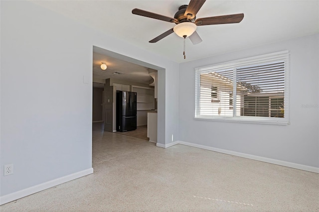 unfurnished room with light speckled floor, ceiling fan, and baseboards