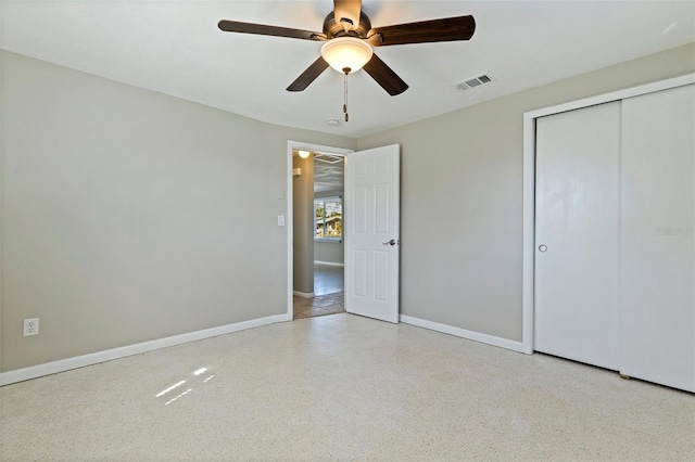 unfurnished bedroom featuring baseboards, visible vents, a ceiling fan, speckled floor, and a closet