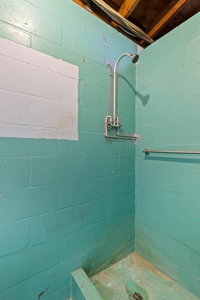 full bath featuring concrete flooring and a tile shower