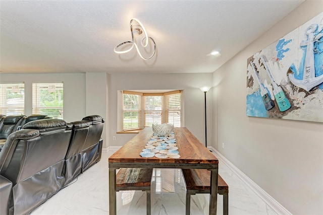 dining room with marble finish floor and baseboards