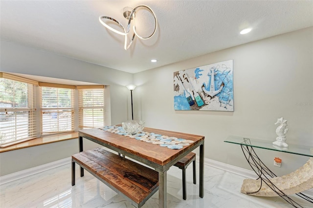 dining area with recessed lighting, marble finish floor, a textured ceiling, and baseboards