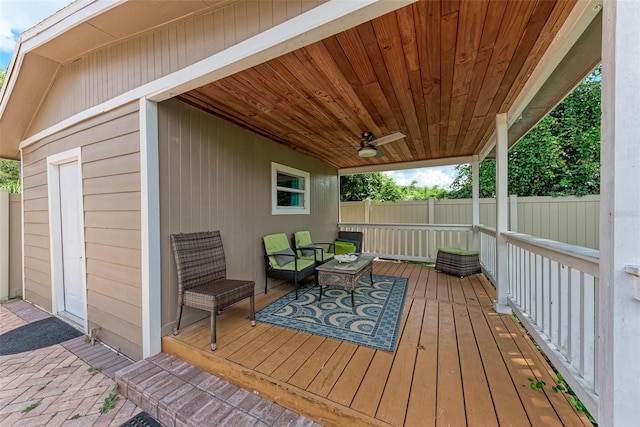 wooden deck featuring a ceiling fan, fence, and an outdoor living space