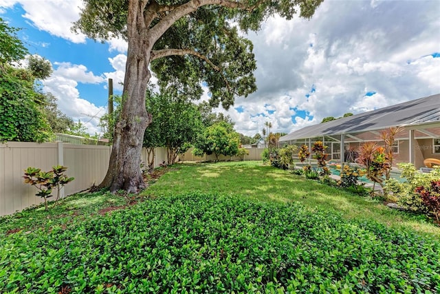 view of yard with a lanai and a fenced backyard