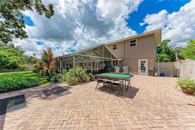 view of patio / terrace with glass enclosure, outdoor dining area, and fence