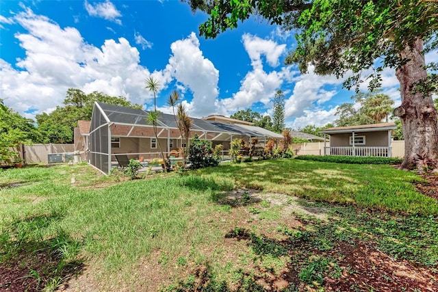 view of yard with glass enclosure and a fenced backyard