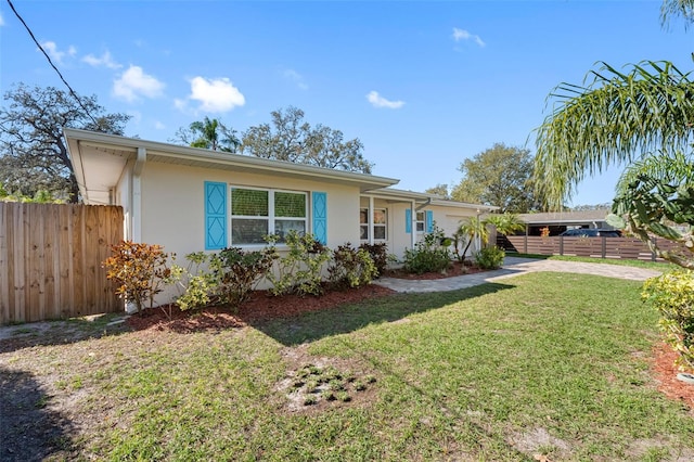 ranch-style home with a front yard, fence, and stucco siding