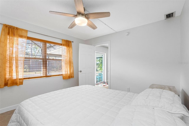 tiled bedroom with baseboards, visible vents, and a ceiling fan