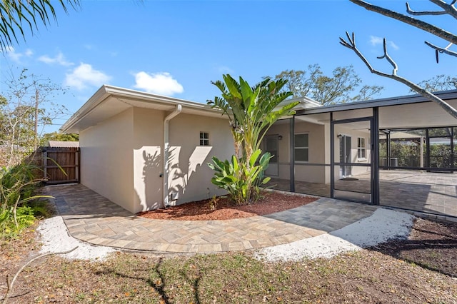 exterior space with a patio, a lanai, fence, and stucco siding