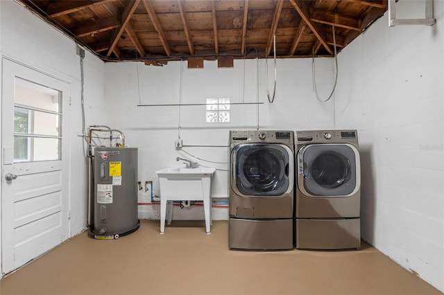 washroom featuring water heater, laundry area, concrete block wall, and washer and dryer