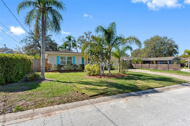 view of front of house featuring a front lawn, fence, and stucco siding