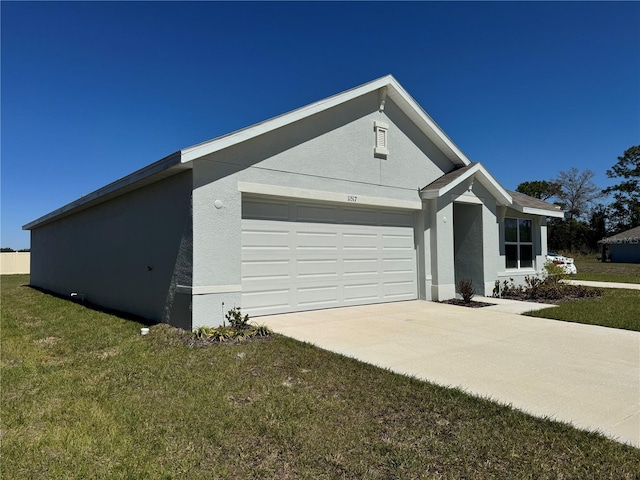 view of side of property with stucco siding, an attached garage, a yard, and driveway