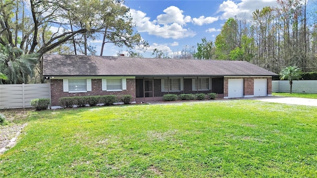 single story home featuring brick siding, a front yard, fence, a garage, and driveway