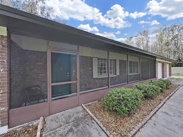 view of side of property with a garage and brick siding