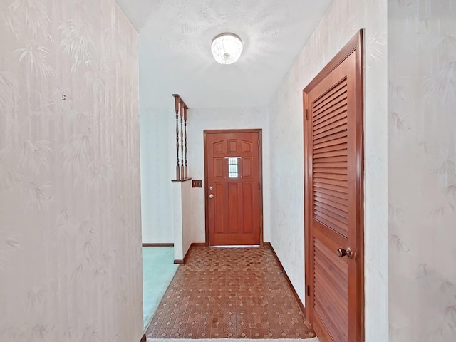 entryway with a textured ceiling and baseboards