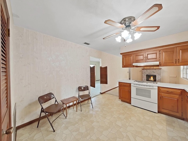 kitchen with white range with electric cooktop, under cabinet range hood, visible vents, light countertops, and brown cabinetry