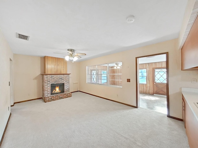 unfurnished living room featuring light carpet, baseboards, a fireplace, and visible vents