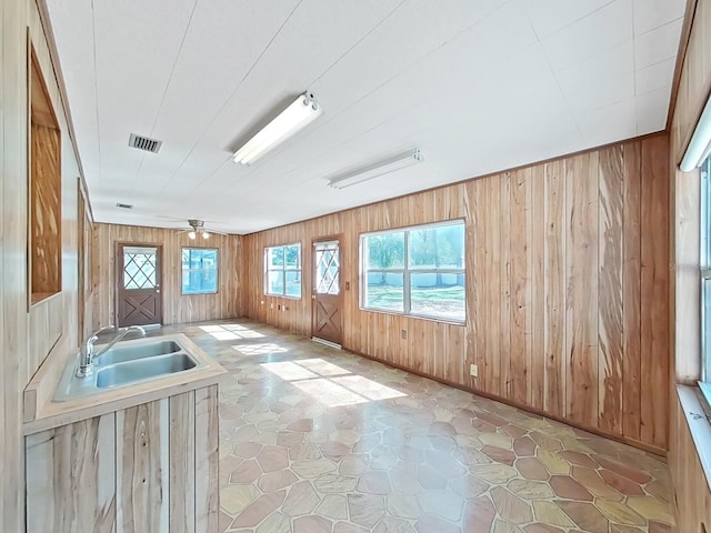 interior space with wood walls, a sink, and visible vents