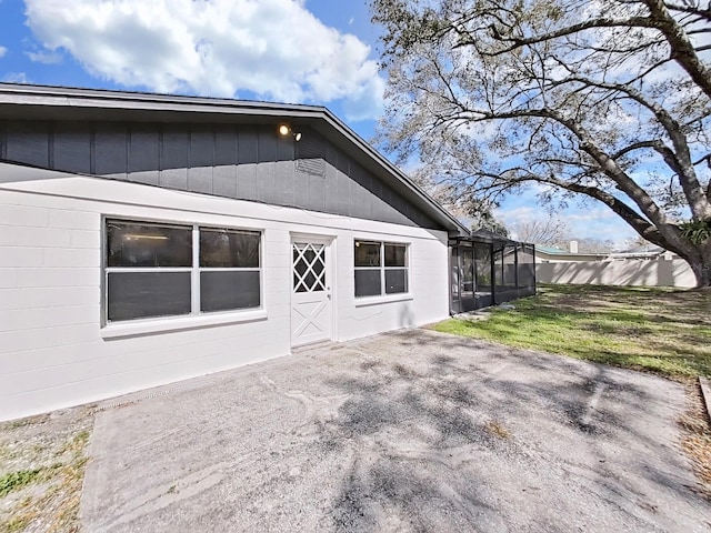 back of house with concrete block siding and a patio area