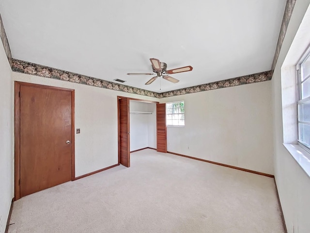 unfurnished bedroom featuring a closet, light carpet, visible vents, and baseboards