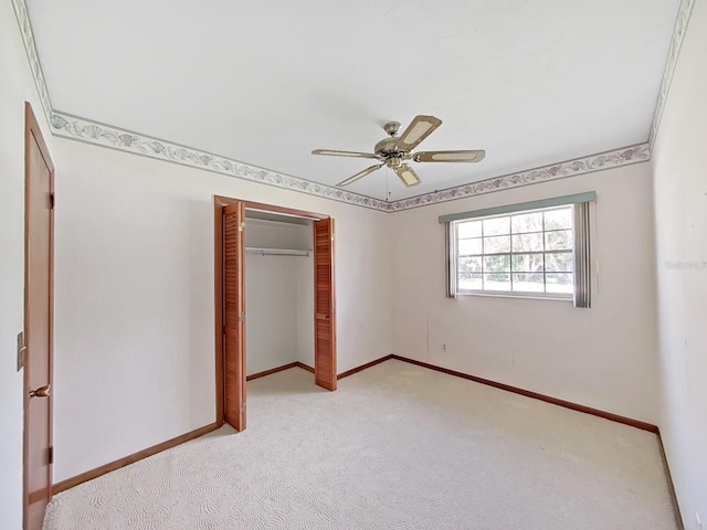 unfurnished bedroom with a ceiling fan, baseboards, a closet, and light colored carpet