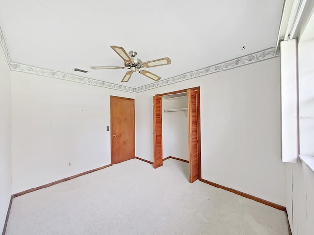 unfurnished bedroom featuring ceiling fan, light carpet, visible vents, baseboards, and a closet