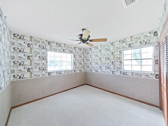 empty room with ceiling fan, carpet floors, visible vents, baseboards, and wallpapered walls