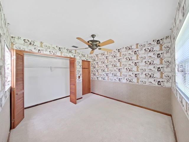 unfurnished bedroom with visible vents, a ceiling fan, light carpet, baseboards, and wallpapered walls