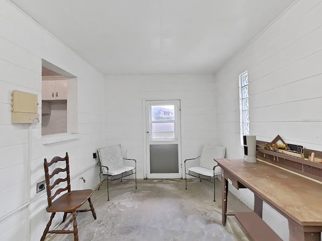 living area with unfinished concrete flooring and a healthy amount of sunlight