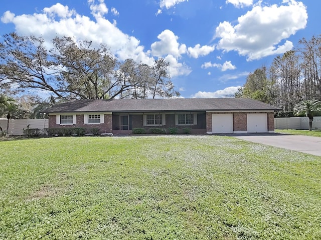 ranch-style house with a garage, driveway, brick siding, and a front yard