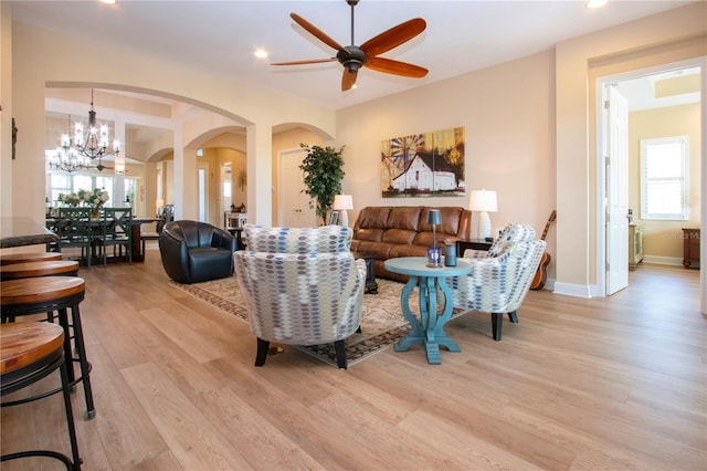 328 Siena Vista Pl, Sun City Center, FL 33573 - living area with baseboards, arched walkways, light wood-style flooring, ceiling fan with notable chandelier, and recessed lighting