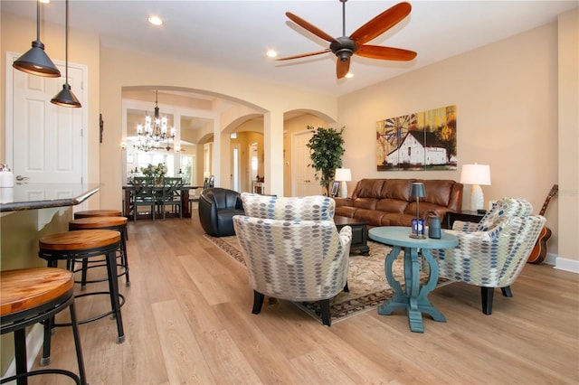 328 Siena Vista Pl, Sun City Center, FL 33573 - living area with arched walkways, light wood finished floors, recessed lighting, baseboards, and ceiling fan with notable chandelier